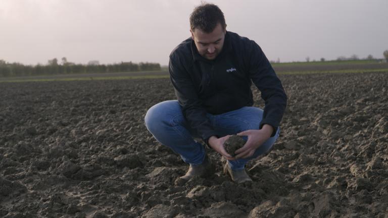 Jonge boer bekijkt bodem